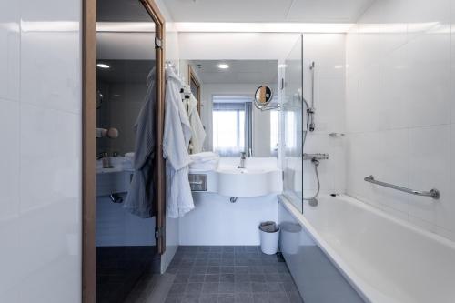 uma casa de banho com um lavatório, uma banheira e um WC. em Holiday Club Vierumäki em Vierumäki