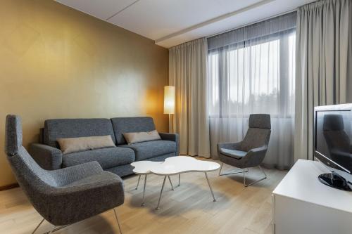 a living room with a couch and chairs and a tv at Holiday Club Vierumäki in Vierumäki