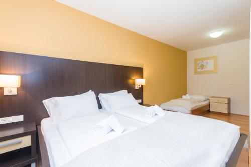 Una habitación de hotel con dos camas con sábanas blancas. en Levant 200 in Marina Portoroz by Locap Group, en Portorož