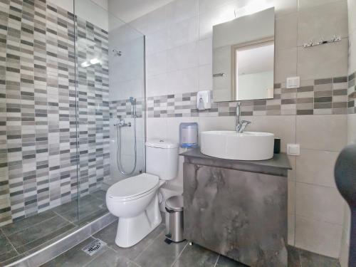 a bathroom with a toilet and a sink and a shower at Epipleon Luxury Suites -105- Δωμάτιο 35τμ με βεράντα 35τμ μπροστά στη θάλασσα in Nafpaktos