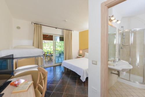 a bedroom with a bed and a bathroom with a sink at Castelsardo Resort Village in Castelsardo