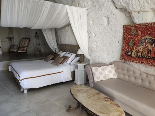 a bedroom with a bed and a couch at Le Manoir des Roches in Bourré