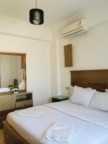 a bedroom with a large white bed and a mirror at Villa 22 in Dahab