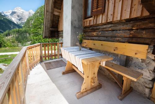 un banc en bois installé sur la terrasse couverte d'une cabine dans l'établissement Mountain heart holiday house, à Trenta