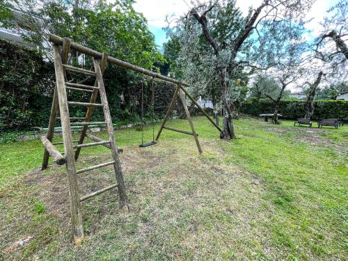 a swing set in a park with a tree at Hotel Stella Alpina in Malcesine