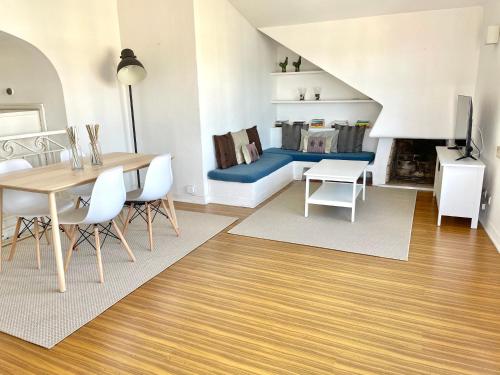 a living room with a table and chairs and a couch at Cascais Terrace Bay Apartment in Cascais