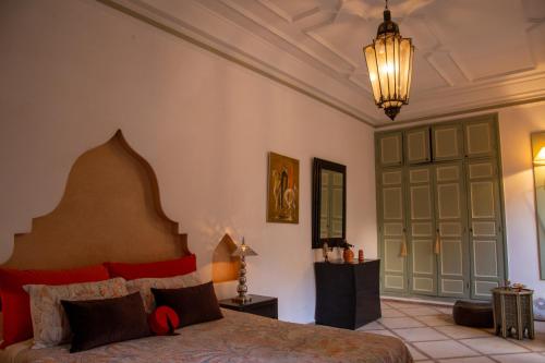 a bedroom with a bed and a chandelier at RIAD KERDOUSS in Marrakesh