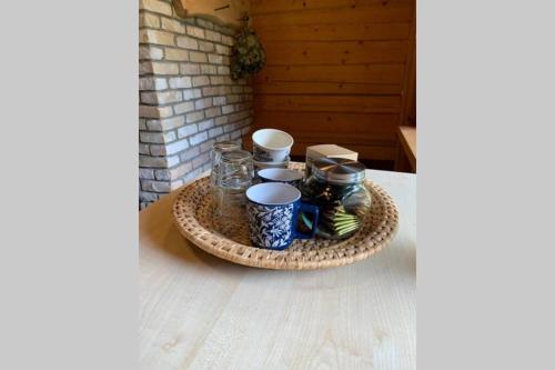 a tray with cups and mugs on a table at Pirtsmāja Villa Marta in Cēsis