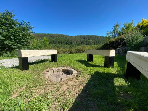two benches sitting in a field with a fire pit at U Tří pecek - Malenice in Malenitz