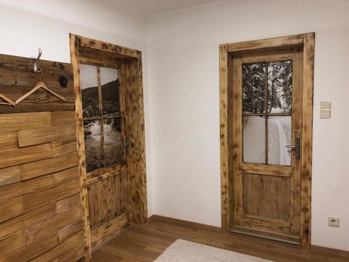 a room with a wooden door and windows at Familienappartements Eder - Free entry to Tauern SPA Kaprun included in Kaprun