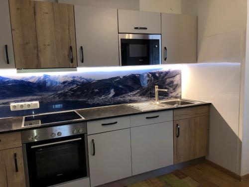 a kitchen with a sink and a stove top oven at Familienappartements Eder - Free entry to Tauern SPA Kaprun included in Kaprun