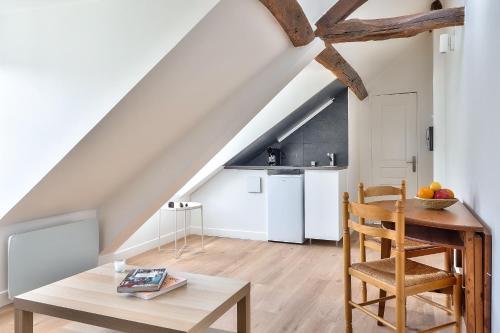un salon avec une table et une cuisine dans l'établissement Charming 1 Bedroom Apt in the Heart of Paris (6F), à Paris