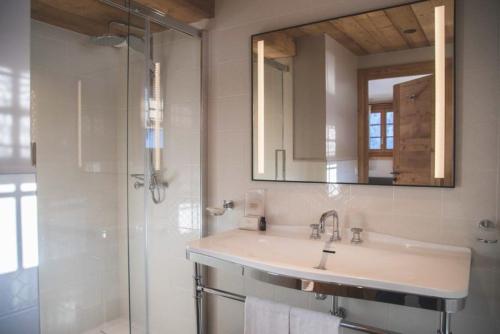 a bathroom with a sink and a shower and a mirror at La Ferme in La Clusaz