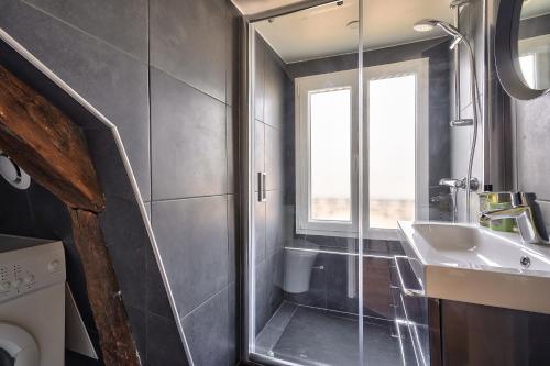 une salle de bain avec un lavabo et une douche en verre dans l'établissement Charming 1 Bedroom Apt in the Heart of Paris (6F), à Paris