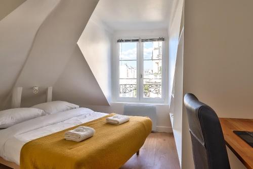 une chambre avec un lit avec deux serviettes dessus dans l'établissement Charming 1 Bedroom Apt in the Heart of Paris (6F), à Paris