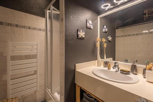 ein Badezimmer mit Waschbecken und Spiegel in der Unterkunft L'Arpege - appartement de charme cœur historique de Vannes in Vannes