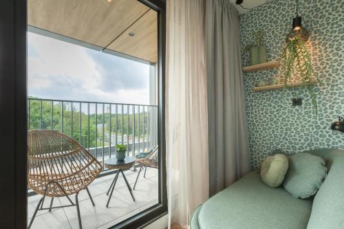 a bedroom with a bed and a balcony with a chair at Van der Valk Hotel Venlo in Venlo