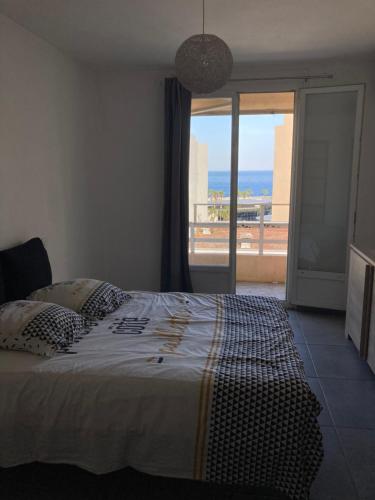 a bedroom with a bed with a view of the ocean at Appartement Bastia Centre in Bastia