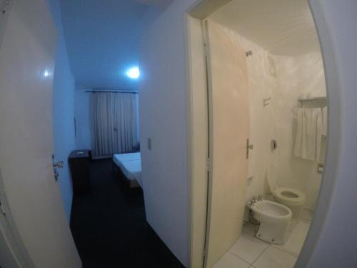 Hotel Cavalinho Branco في أغواس دي يندويا: حمام ابيض مع مرحاض ومغسلة