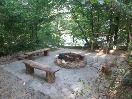 a fire pit with two benches and a fire oven at Domek na wzgórzu "WILK" in Świątkowa Mała