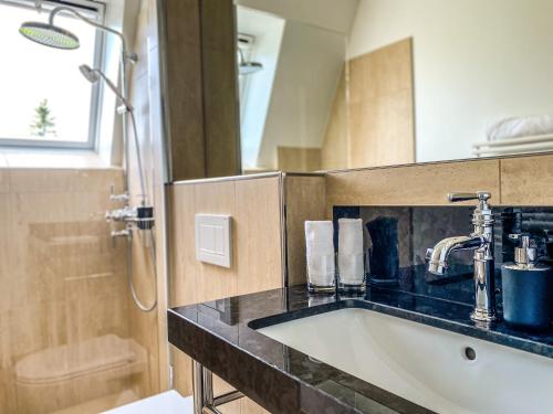 a bathroom with a sink and a shower at Trompeterschlössle Hotel & Residence in Tägerwilen