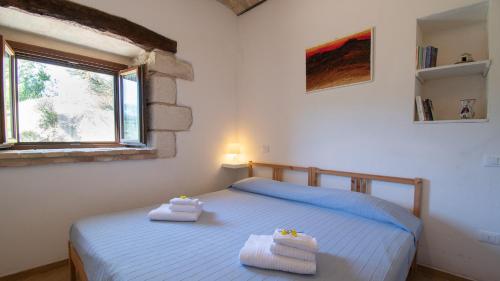 a bedroom with a bed with two towels on it at Borgo Majella by Rentbeat in Abbateggio