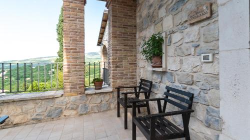 two chairs sitting on a patio with a stone wall at Borgo Majella by Rentbeat in Abbateggio