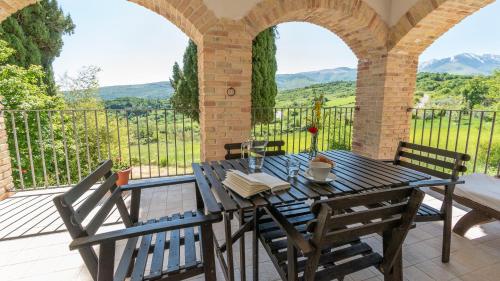 a table and chairs on a patio with a view of mountains at Borgo Majella by Rentbeat in Abbateggio