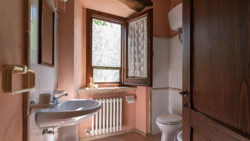 a bathroom with a sink and a toilet and a window at Borgo Majella by Rentbeat in Abbateggio