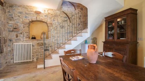 a dining room with a wooden table and a stone wall at Borgo Majella by Rentbeat in Abbateggio