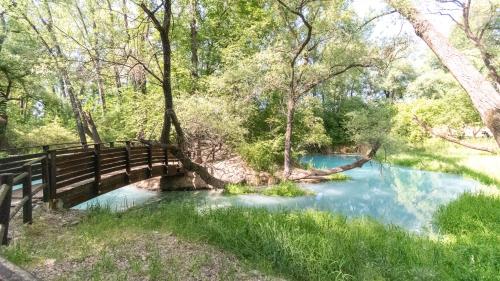 a wooden bridge over a river in a forest at Borgo Majella by Rentbeat in Abbateggio