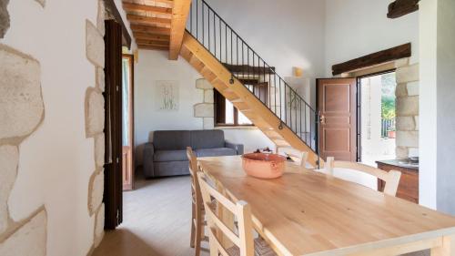 a dining room with a wooden table and a staircase at Borgo Majella by Rentbeat in Abbateggio