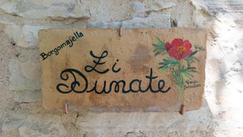 a sign on a wall with a flower on it at Borgo Majella by Rentbeat in Abbateggio
