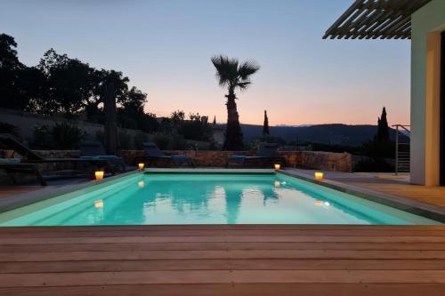 una piscina con una palmera al fondo en Villa Maria 12 pers piscine chauffée 5 min plage en voiture, en Sainte-Lucie de Porto-Vecchio
