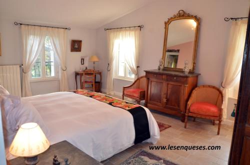 La Bastide des Enquèses في لورج: غرفة نوم بسرير ومرآة وخزانة
