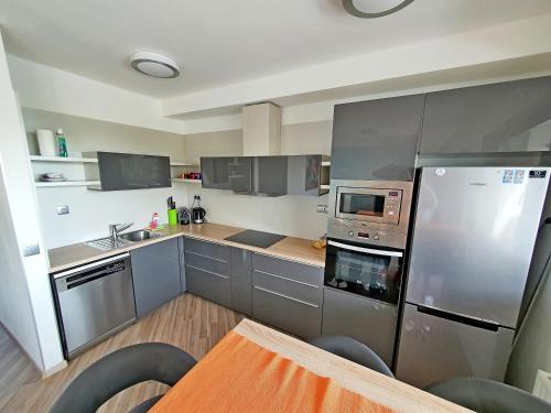 a kitchen with stainless steel appliances and wooden floors at Silver DeLux Apartman in Balatonfüred