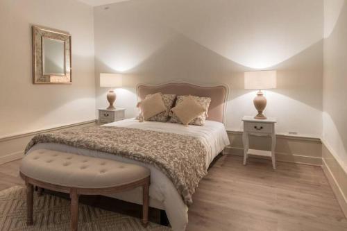 a bedroom with a bed with two tables and two lamps at Chez la Tante Louise - appartement privé de charme in Passenans