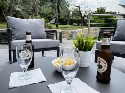 a table with two bottles of beer and a bowl of chips at Hotel Stella Alpina in Malcesine