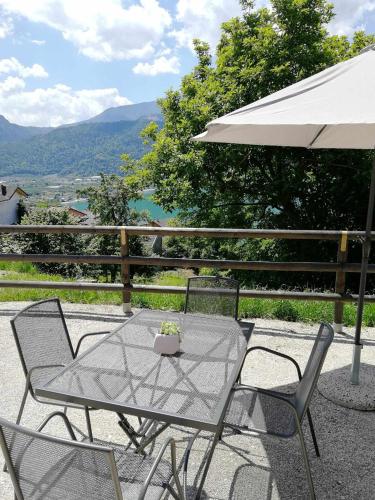 a table and chairs with an umbrella on a patio at Numero 53 Tenna OSPITAR in Tenna 