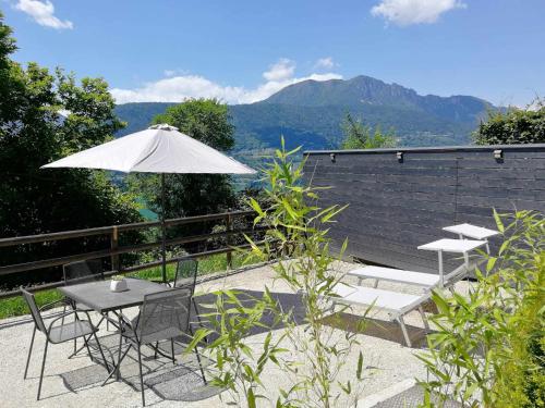 a patio with a table and chairs and an umbrella at Numero 53 Tenna OSPITAR in Tenna 