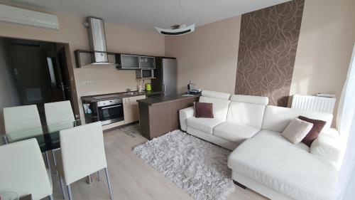 a living room with a white couch and a kitchen at Silver DeLux Apartman in Balatonfüred