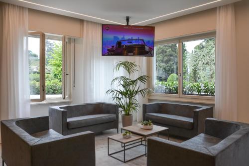 a living room with couches and a large screen at Hotel Stella Alpina in Malcesine