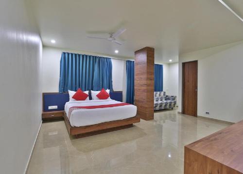 a bedroom with a bed with red pillows at Hotel The Kuber in Dwarka