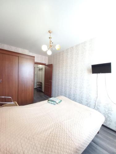 a bedroom with a bed and a tv on the wall at Apartament on 30 Devizii in Irkutsk