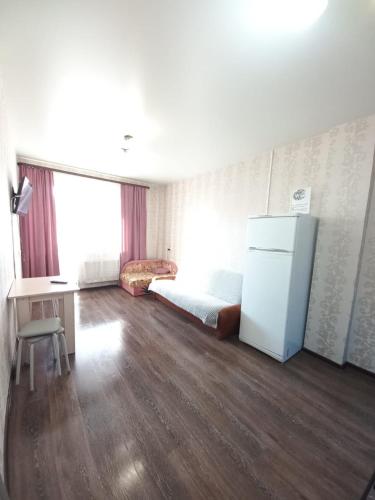 a room with a bed and a refrigerator in it at Apartament on 30 Devizii in Irkutsk