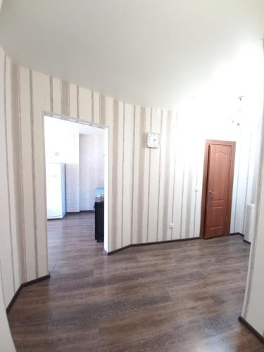 an empty room with a hallway with striped walls and a door at Apartament on 30 Devizii in Irkutsk