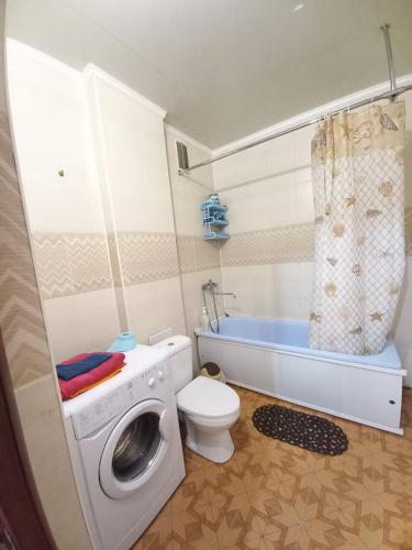 a bathroom with a washing machine and a toilet at Apartament on 30 Devizii in Irkutsk