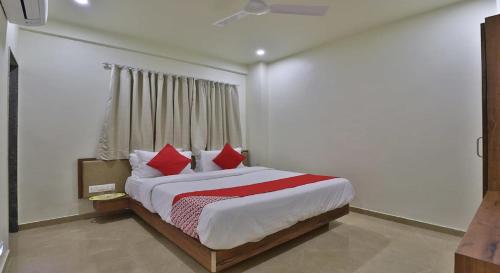 a bedroom with a large bed with red pillows at Hotel Kuber in Dwarka