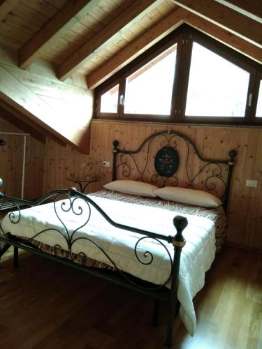 a bedroom with a bed in a room with windows at Botton D' Oro in Cornalba