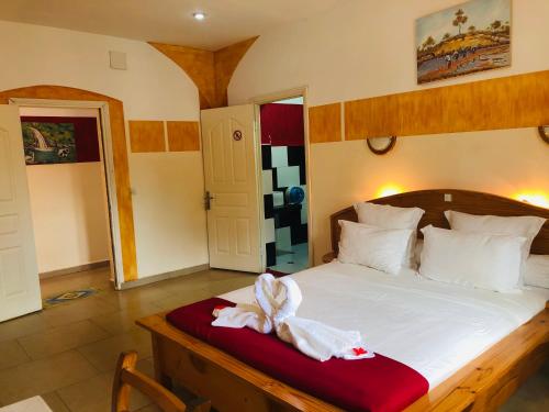 a bedroom with a bed with towels on it at Petite Flower Guest House in Talata-maty